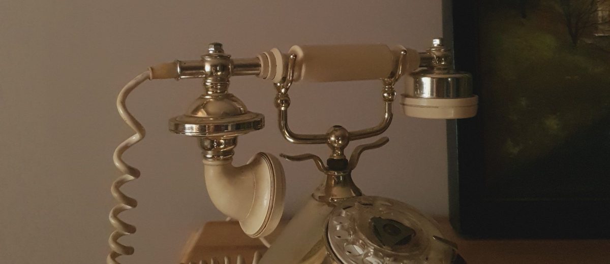 Starý pevný telefon na stolku