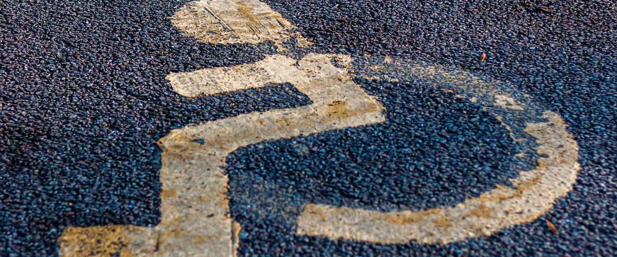 Symbol vozíčkáře na vyhrazeném parkovacím místě
